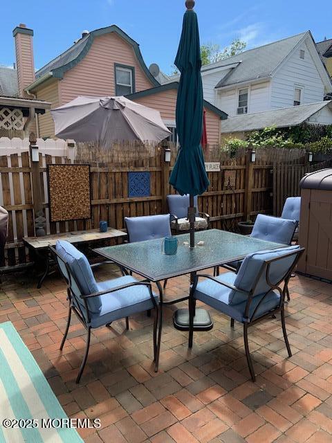 84 Mt Zion Way, Unit 1 Ocean Grove, NJ 07756 - Photo 16 of 16 a view of a patio with a table chairs and a small yard