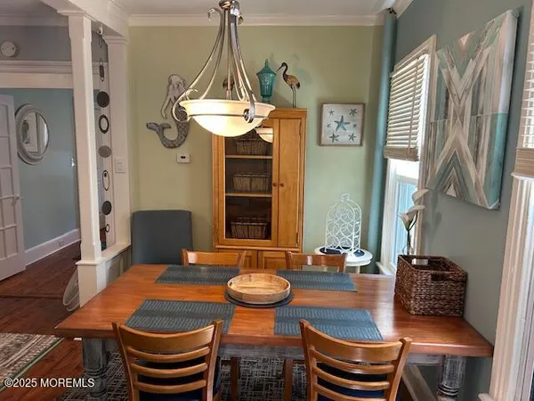 a view of a dining room with furniture a chandelier and wooden floor