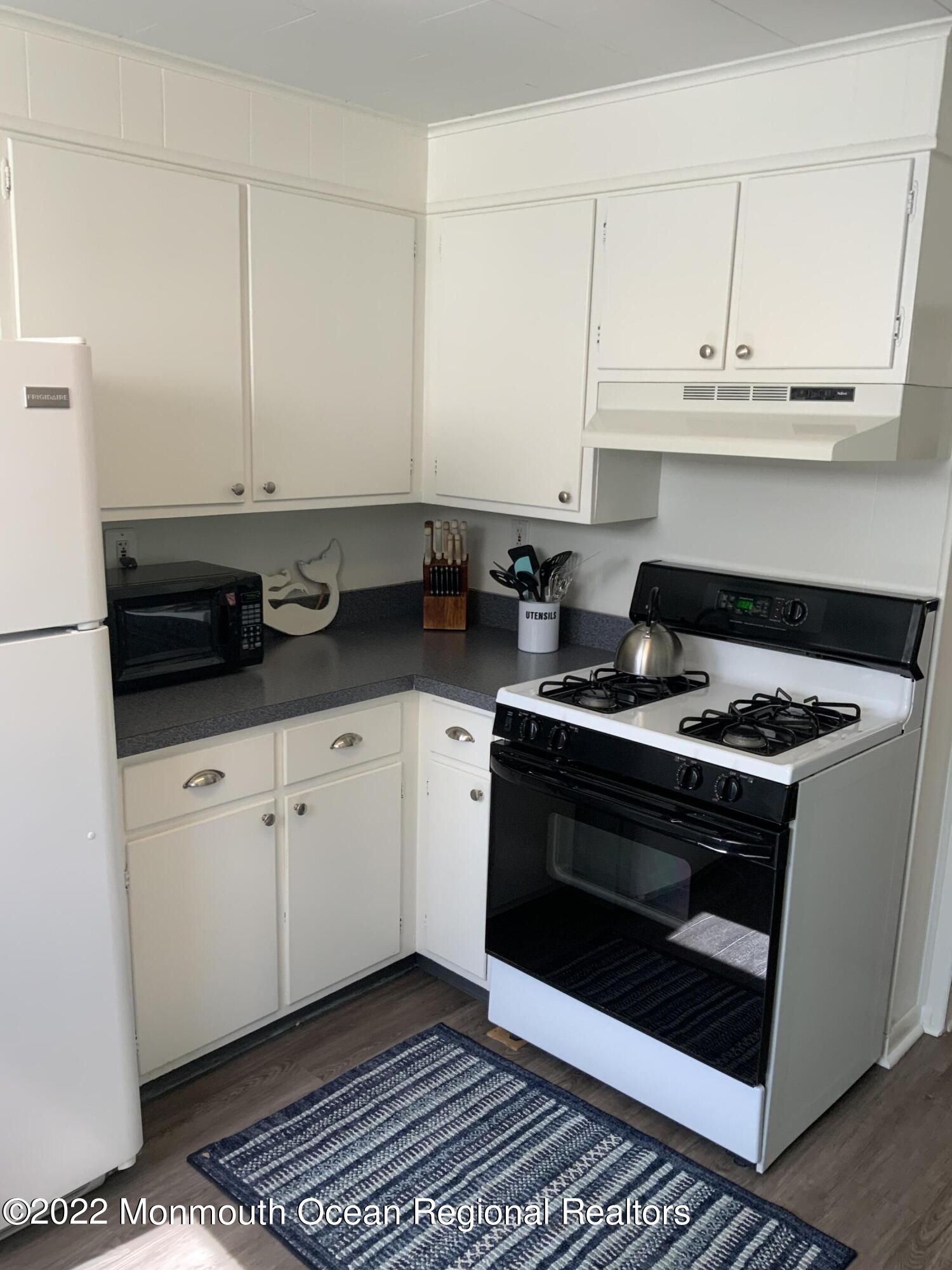 84 Mt Zion Way, Unit 1 Ocean Grove, NJ 07756 - Photo 10 of 16 a kitchen with stainless steel appliances granite countertop a stove a sink and white cabinets