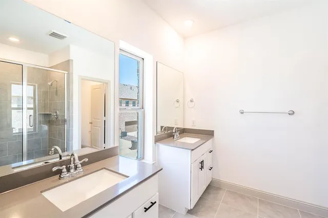 a bathroom with a sink double vanity granite tub shower and a mirror
