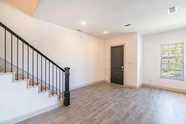 a view of a hallway with wooden floor and entryway