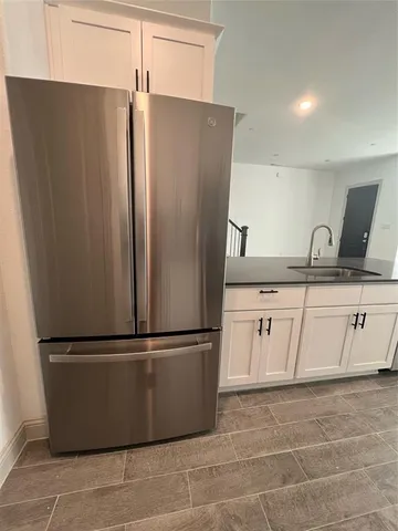a kitchen with a refrigerator sink and cabinets