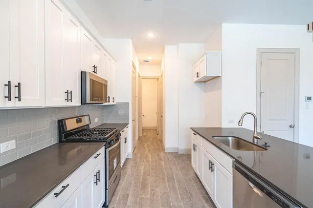 a kitchen with a sink appliances cabinets and a counter top space