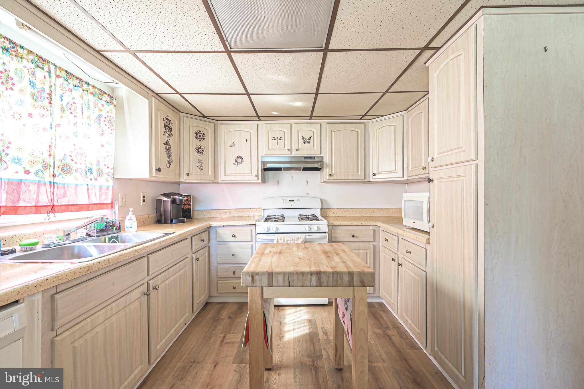 311 Woodruff Carmel Road Bridgeton, NJ 08302 - Photo 14 of 40 a kitchen with stainless steel appliances a stove a sink and white cabinets