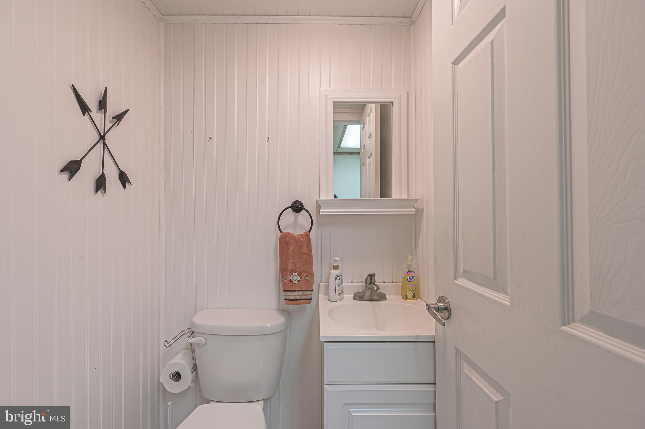 311 Woodruff Carmel Road Bridgeton, NJ 08302 - Photo 17 of 40 a bathroom with a toilet sink vanity and mirror