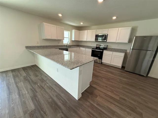 a kitchen with wooden floors and refrigerator