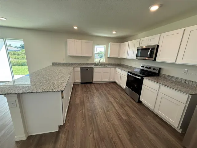 a kitchen with a sink a microwave a stove and cabinets