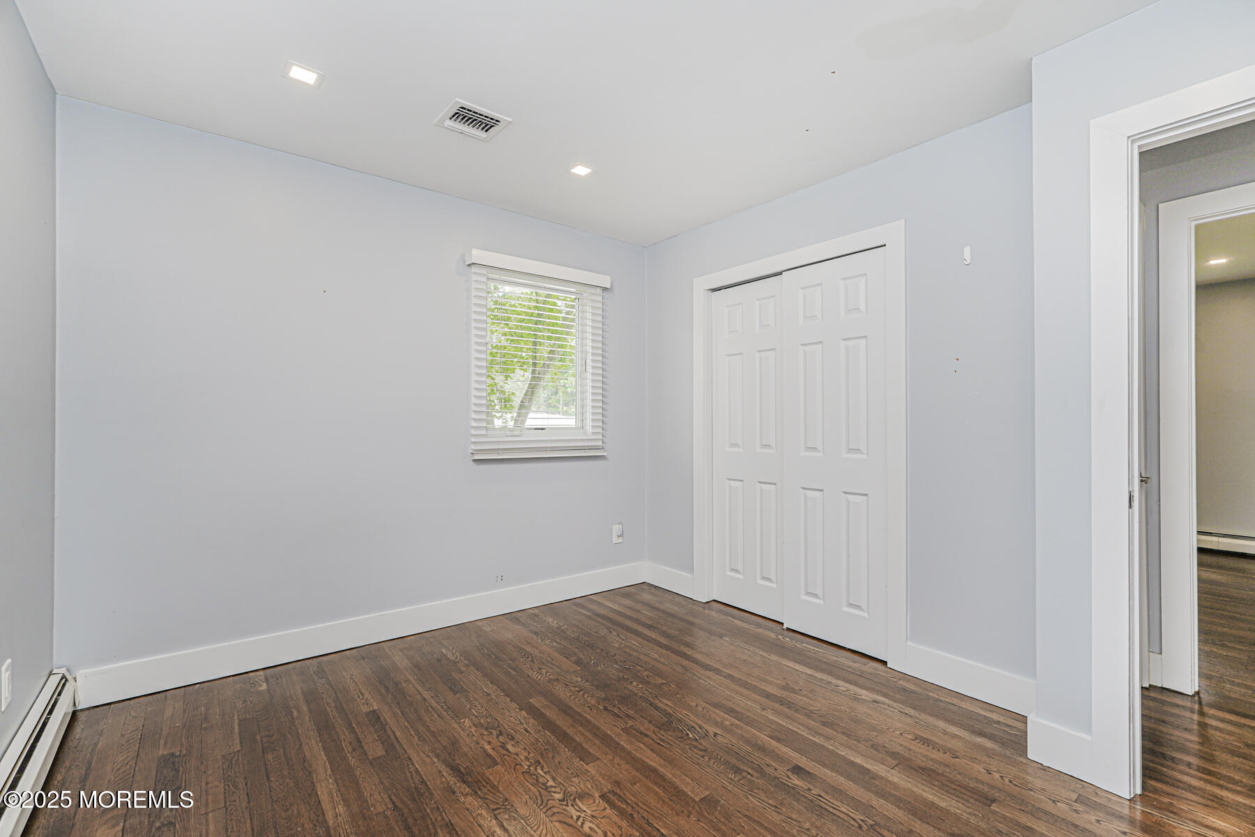 220 Highwood Road Oakhurst, NJ 07755 - Photo 20 of 30 an empty room with wooden floor and a window