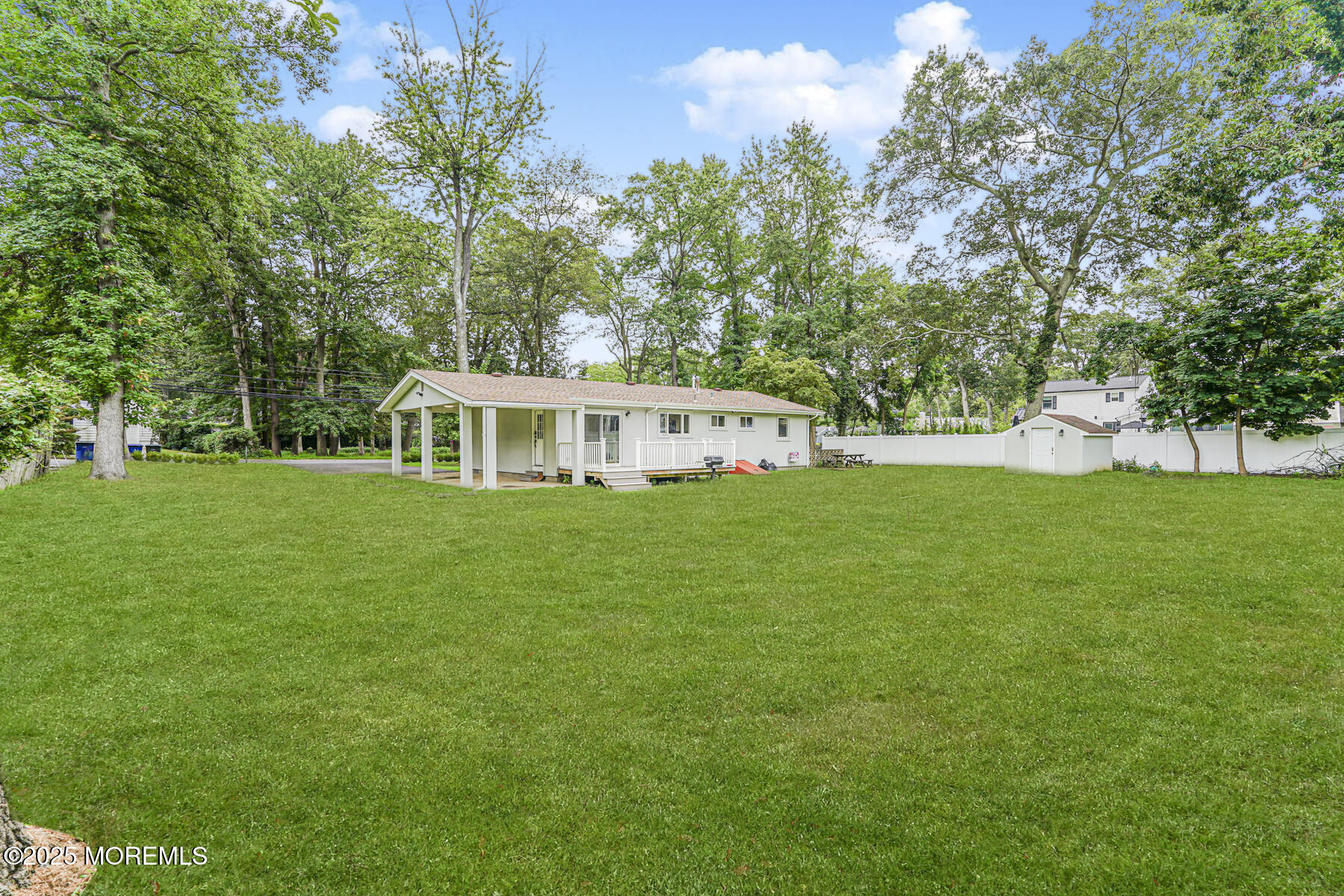 220 Highwood Road Oakhurst, NJ 07755 - Photo 8 of 30 a white house with a big yard and large trees