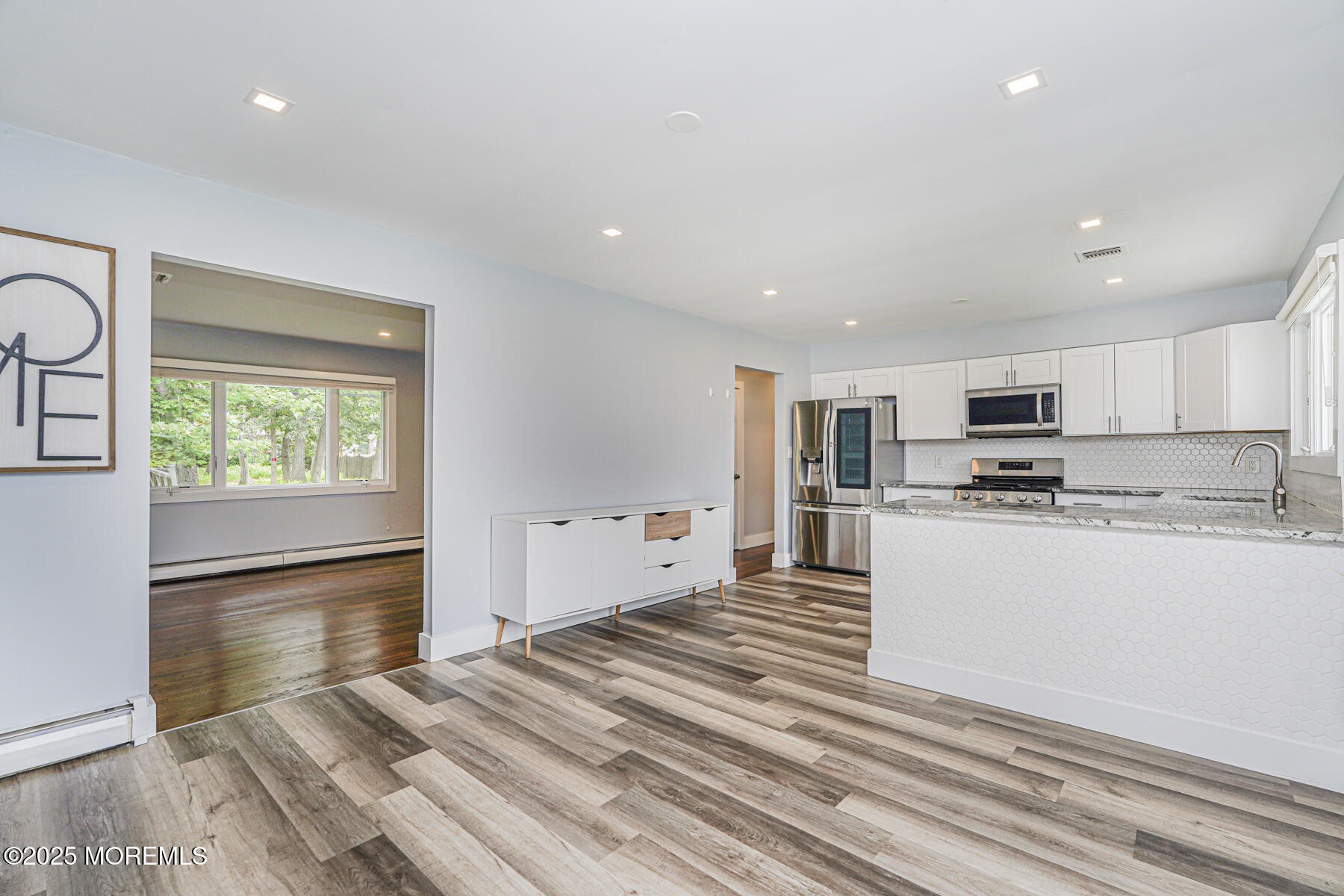 220 Highwood Road Oakhurst, NJ 07755 - Photo 10 of 30 a large white kitchen with kitchen island a stove a sink and a refrigerator