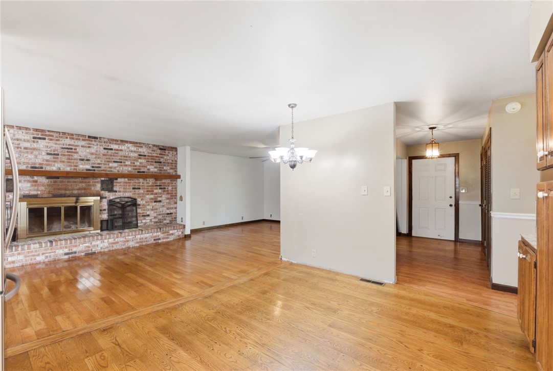 6711 Hamilton-Middletown Road Franklin, OH 45005 - Photo 10 of 49 This living space features warm hardwood floors and a brick fireplace, offering a cozy ambiance.