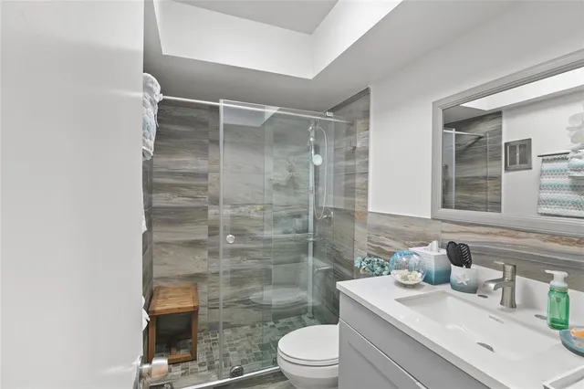 a bathroom with a sink a toilet and shower