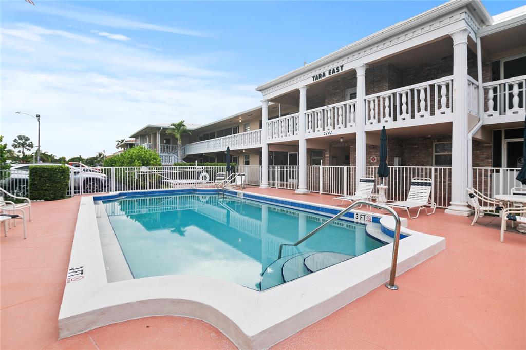 2141 Northeast 68th Street, Unit 107 Fort Lauderdale, FL 33308 - Photo 2 of 20 a view of a patio with swimming pool table and chairs