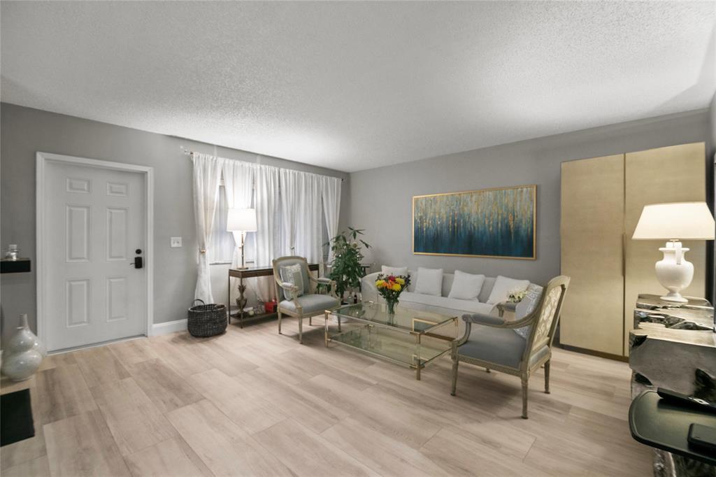 2141 Northeast 68th Street, Unit 107 Fort Lauderdale, FL 33308 - Photo 3 of 20 a living room with furniture and wooden floor