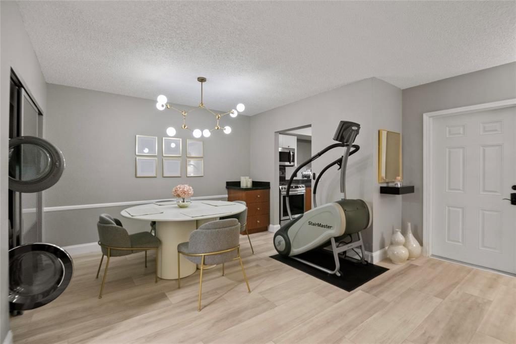 2141 Northeast 68th Street, Unit 107 Fort Lauderdale, FL 33308 - Photo 5 of 20 a living room with furniture a dining table chairs and a chandelier