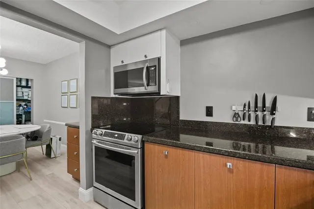 a kitchen with granite countertop a stove and a microwave