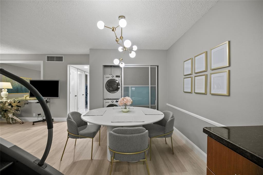 2141 Northeast 68th Street, Unit 107 Fort Lauderdale, FL 33308 - Photo 8 of 20 a view of a dining room with furniture wooden floor and chandelier