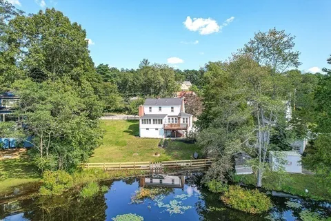 an aerial view of residential houses with outdoor space and trees