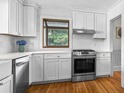 a kitchen with white cabinets and appliances