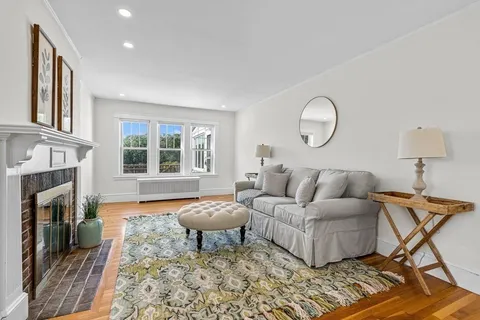 a living room with furniture a fireplace and a window