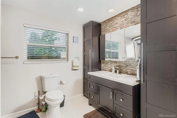 a bathroom with a sink a toilet a mirror and a window