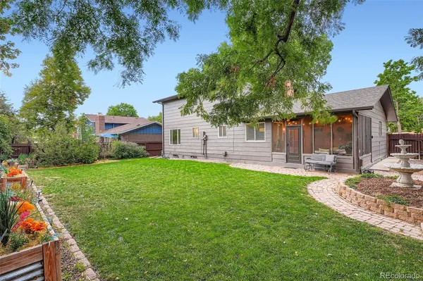 a view of a house with backyard and a tree
