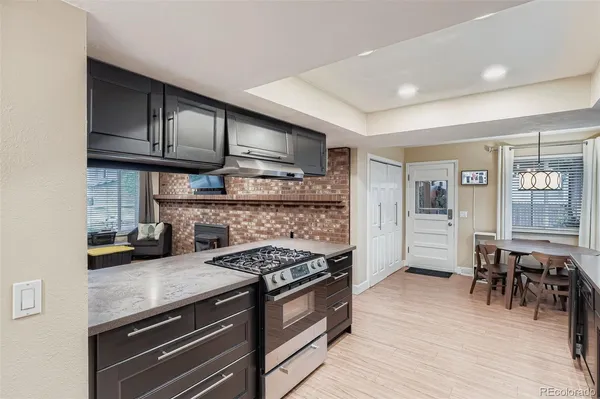 a kitchen with granite countertop a stove and a wooden floors