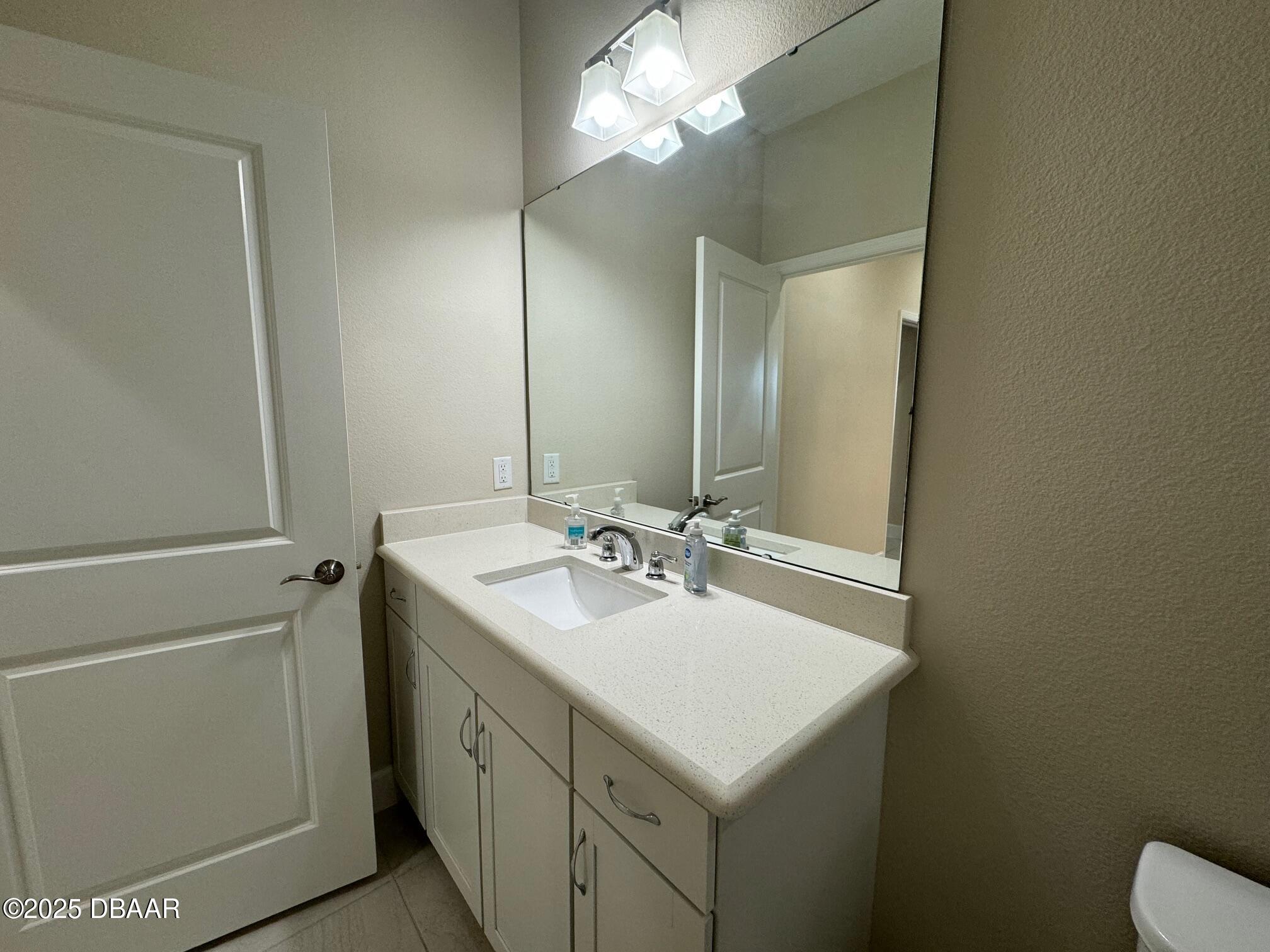 1016 Sea Shell Court Daytona Beach, FL 32124 - Photo 13 of 25 a bathroom with a sink a toilet and a mirror