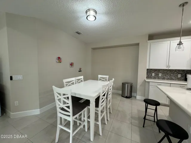 a view of a dining room with furniture and a chandelier