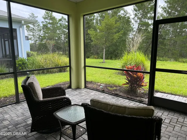 a view of a porch with furniture and a yard