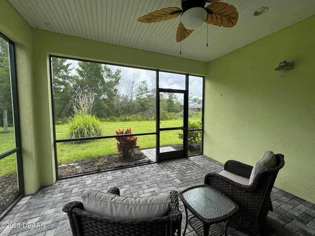 a view of a porch with furniture and a yard