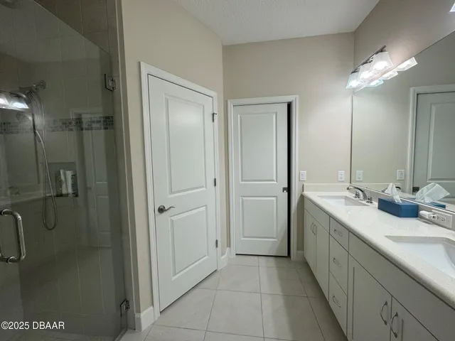 a bathroom with a double vanity sink mirror and shower