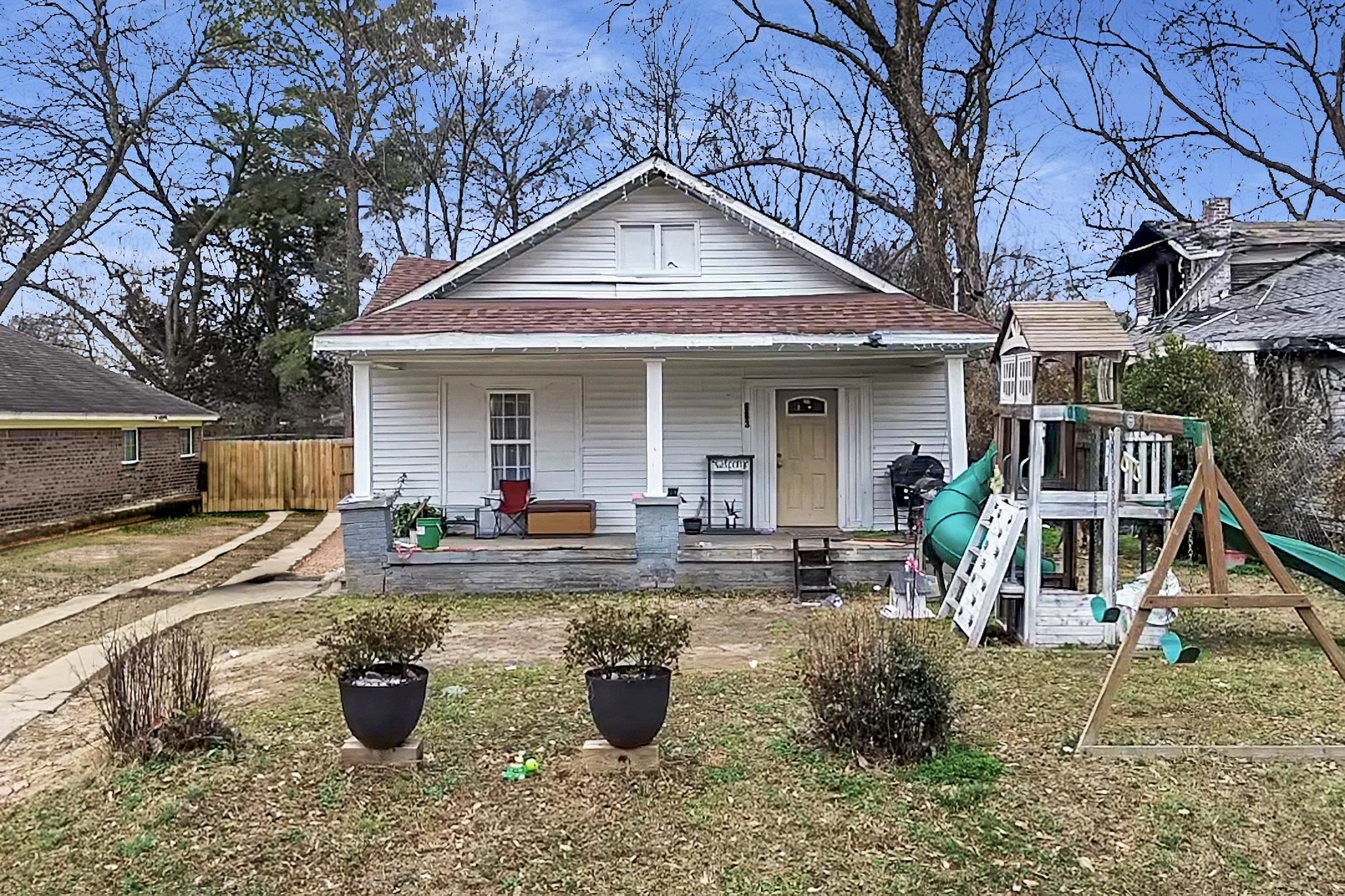 a view of a house with backyard and sitting area