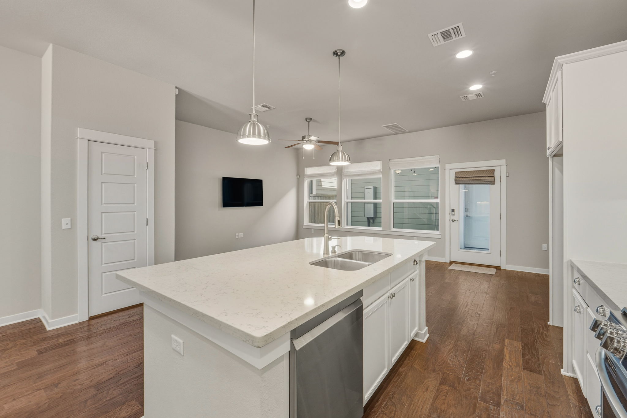 3919 Vaughan Street Austin, TX 78723 - Photo 14 of 40 Sleek island kitchen with quartz countertops and pendant lighting anchors this bright, open living space.