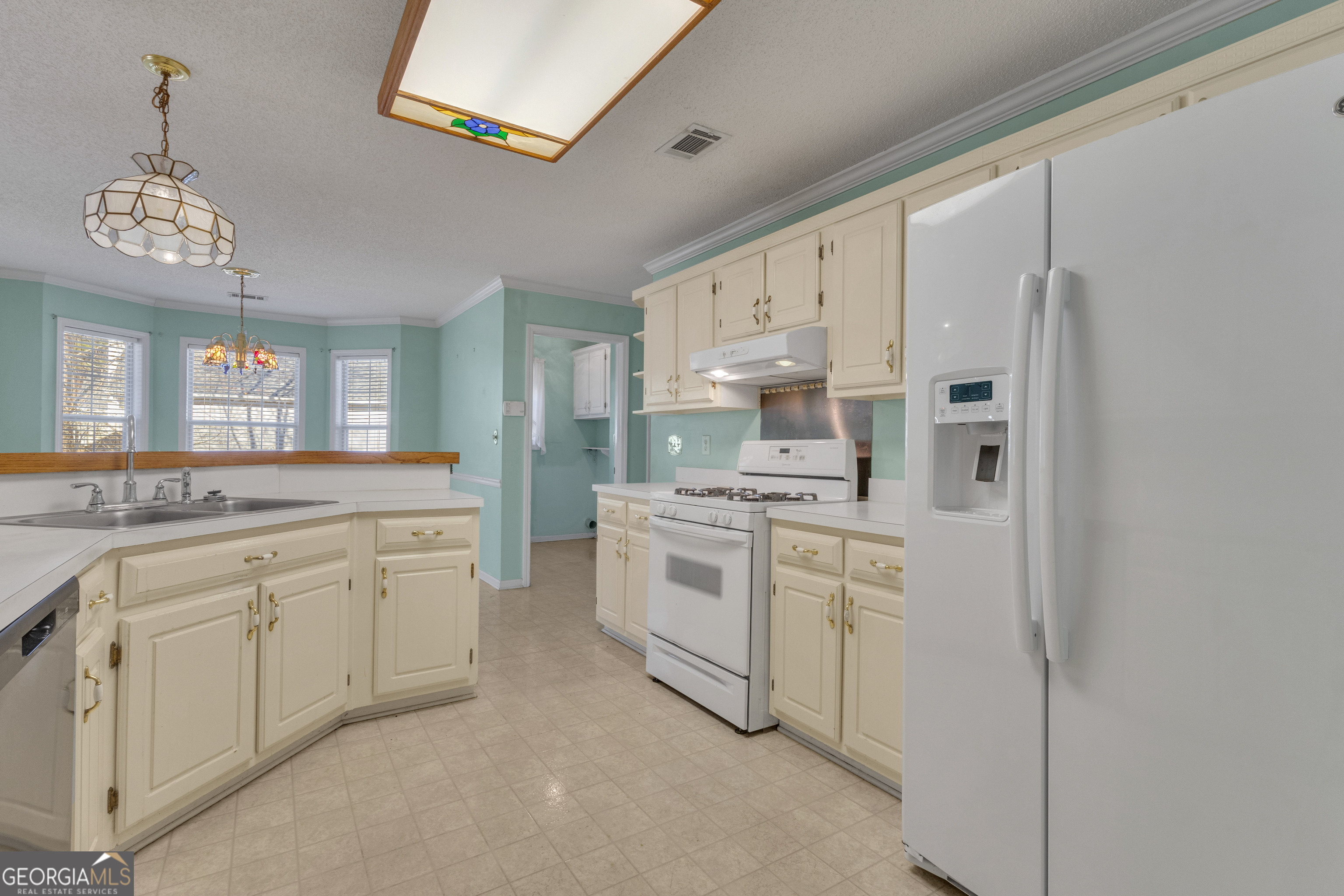 165 Masters Drive Newnan, GA 30265 - Photo 12 of 63 a kitchen with white cabinets and white appliances