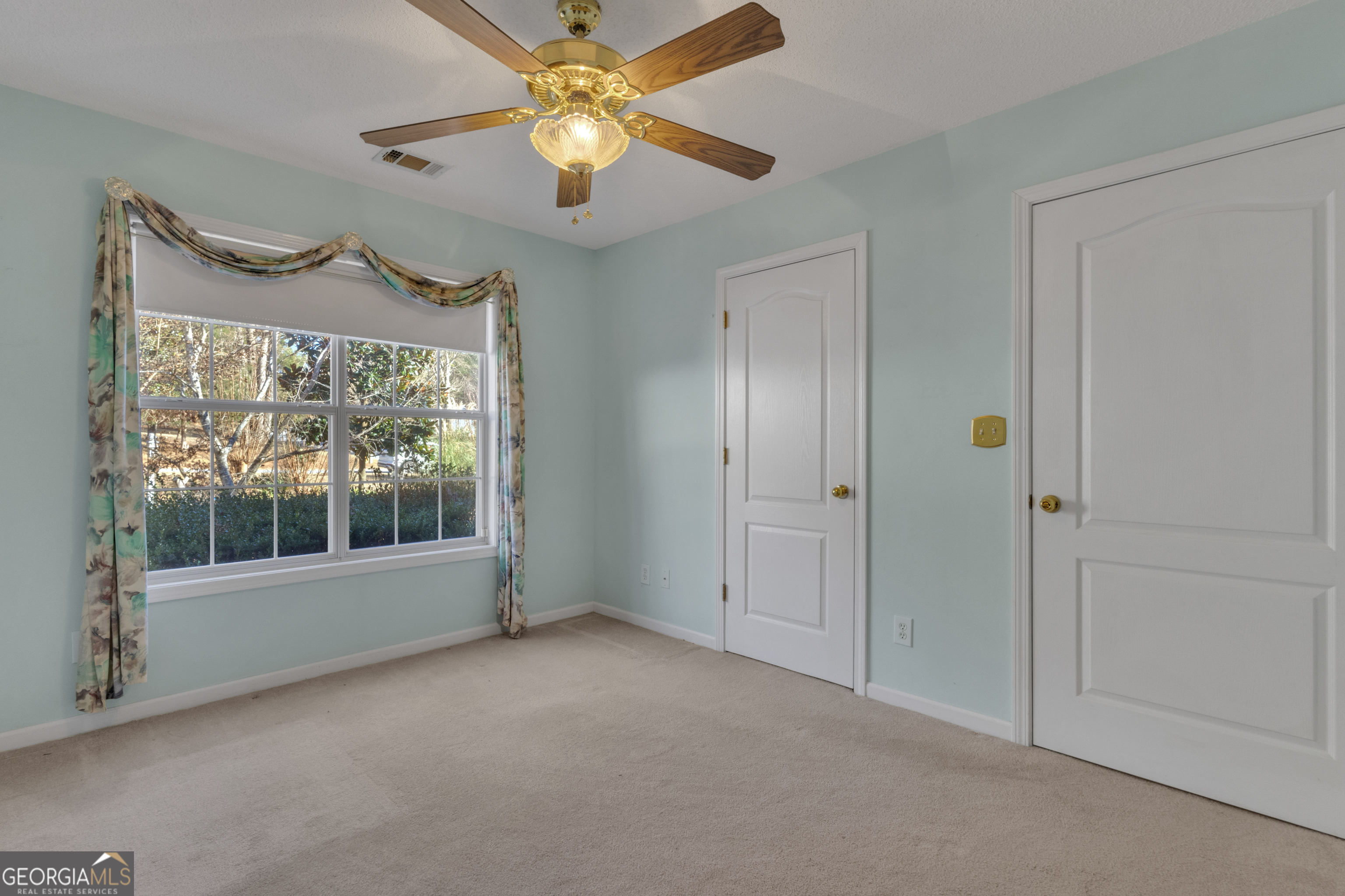 165 Masters Drive Newnan, GA 30265 - Photo 39 of 63 an empty room with a ceiling fan and a window
