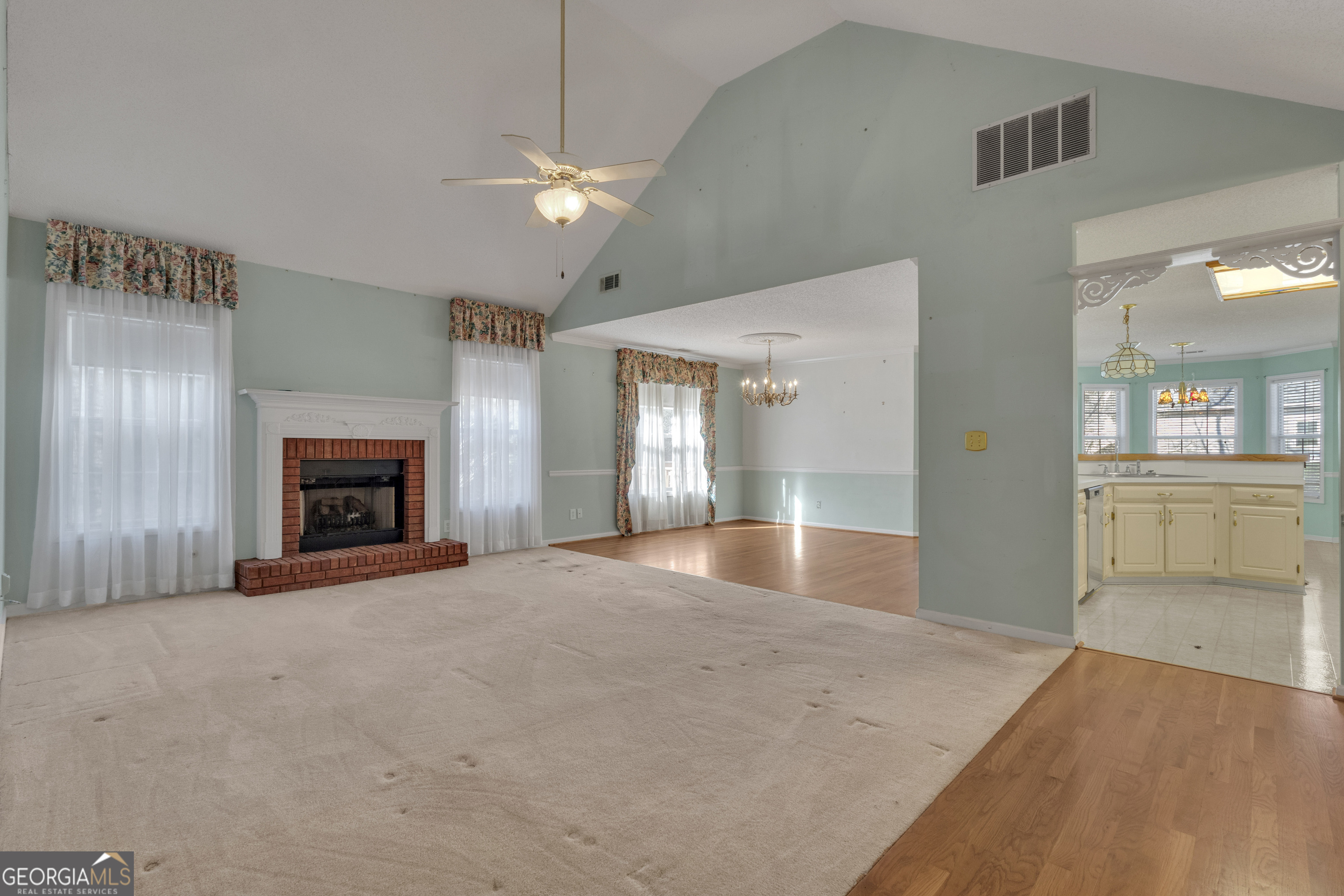 165 Masters Drive Newnan, GA 30265 - Photo 8 of 63 an empty room with fan and kitchen view