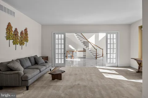 a living room with furniture hard wood floor and a window