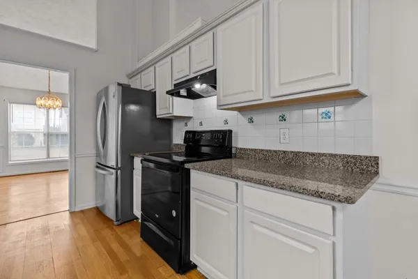 a kitchen with stainless steel appliances granite countertop a refrigerator sink and cabinets