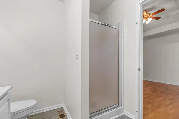 a bathroom with a granite countertop toilet and a shower