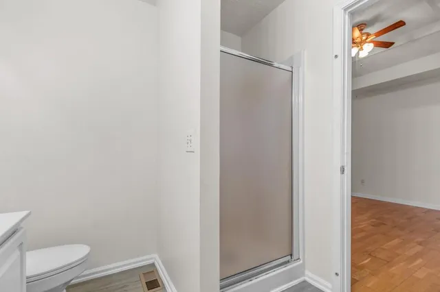a bathroom with a granite countertop toilet and a shower
