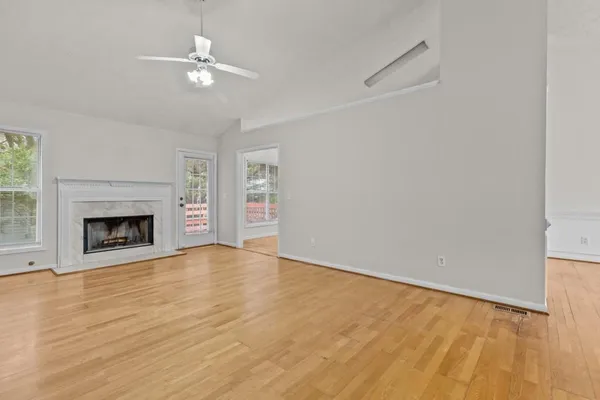 a view of an empty room with a fireplace and a window