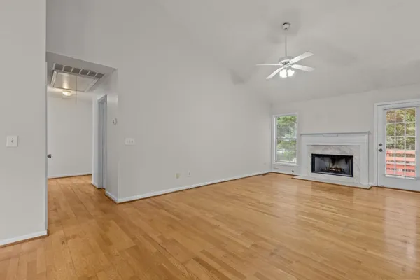a view of empty room with fireplace and wooden floor