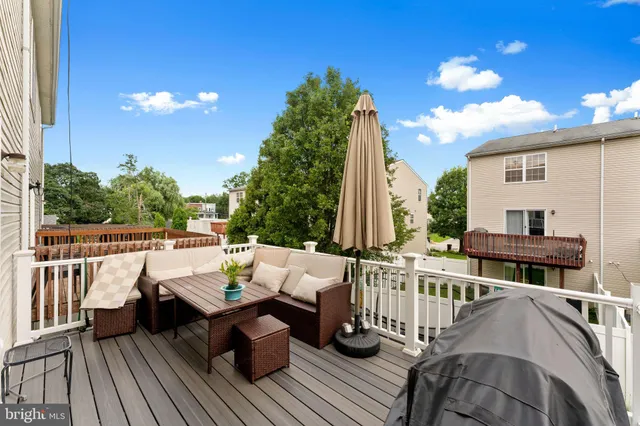 a view of a white house with a big yard and potted plants