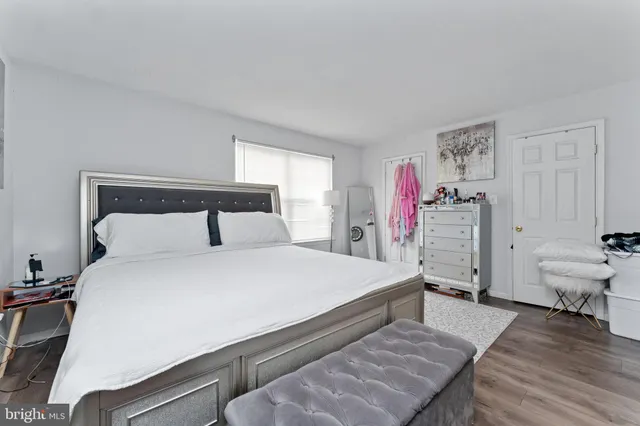 a bedroom with a bed and a wooden floor