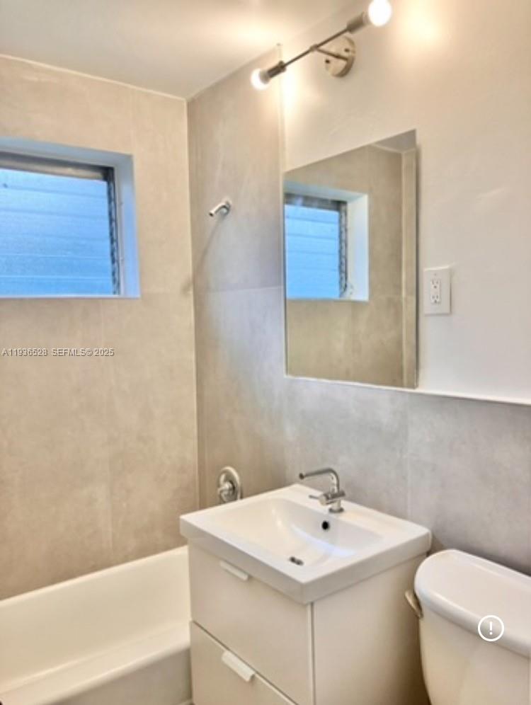 2538 Southwest 11th Street, Unit 2 Miami, FL 33135 - Photo 4 of 8 a bathroom with a sink a toilet and mirror