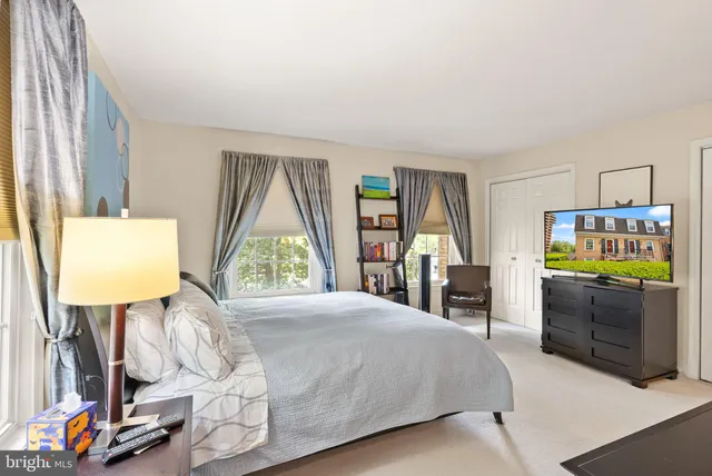 a bed room with a bed window and a flat tv screen