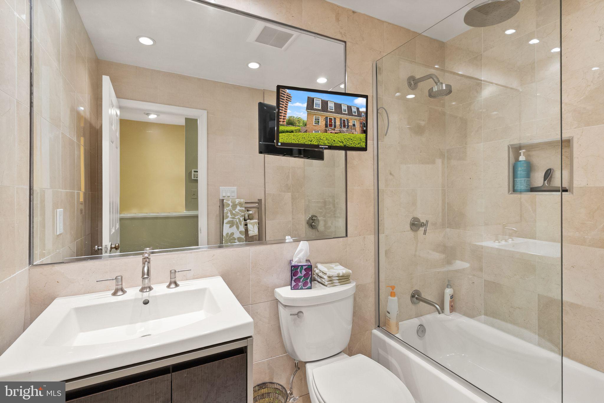 3267 Sutton Place Northwest, Unit C Washington, DC 20016 - Photo 16 of 21 a bathroom with a sink toilet a shower and a mirror