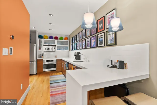 a living room with stainless steel appliances kitchen island a table and chairs in it