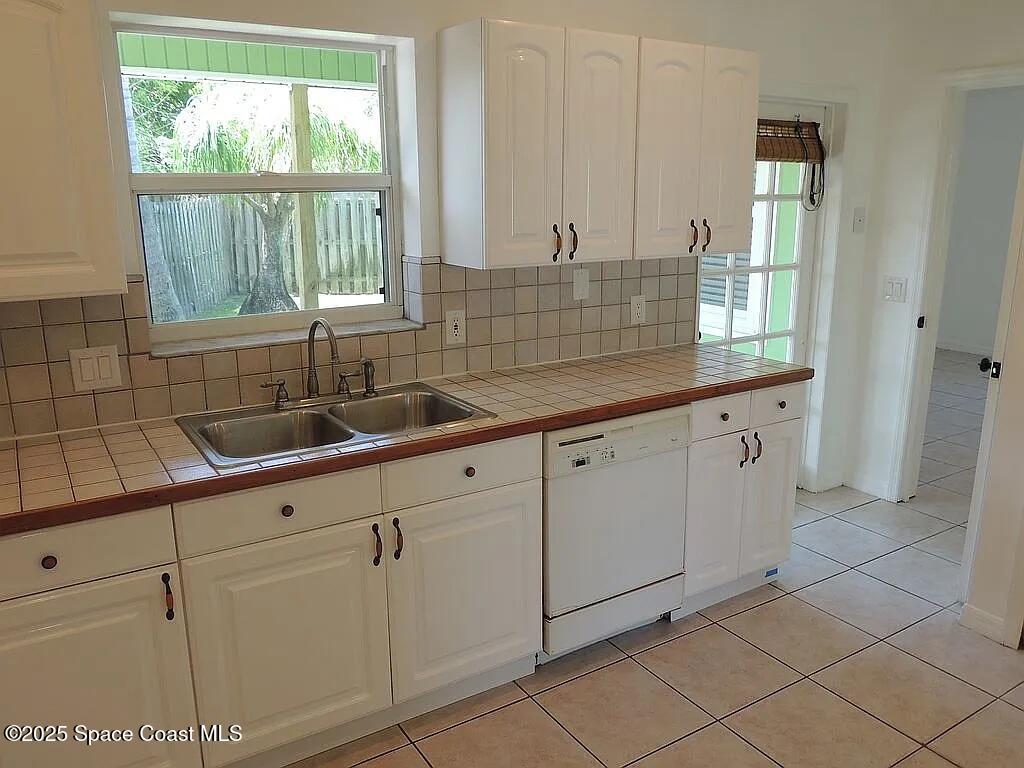 206 4th Avenue Indialantic, FL 32903 - Photo 15 of 43 a kitchen with white cabinets and sink